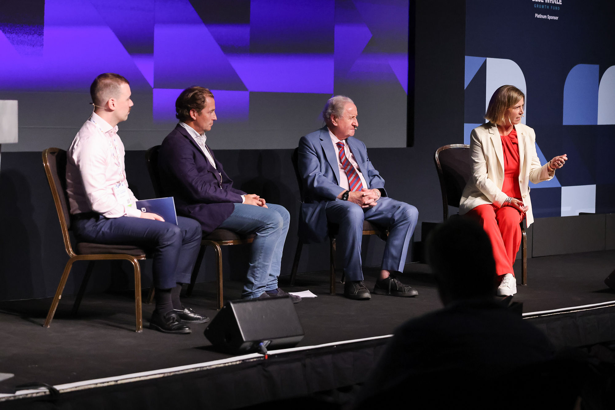 Panel discussion with four speakers on stage at Investor Summit